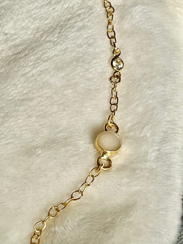 Deze armband heeft een geboortesteen en een moedermelk bedel