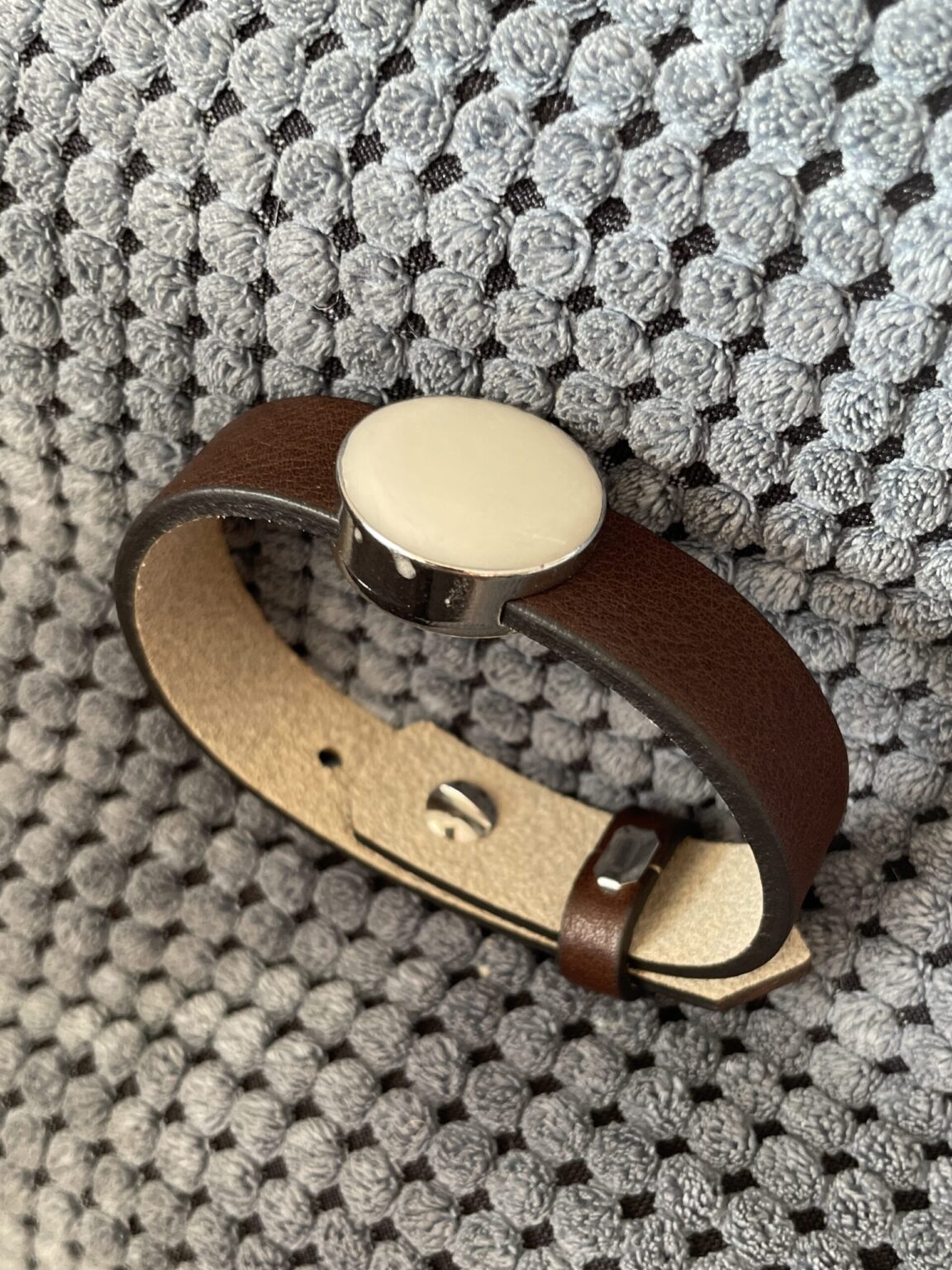 In de slider die je op de leren armband schuift is moedermelk verwerkt en hard gemaakt als een witte steen.