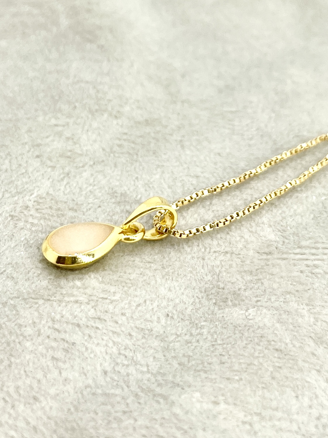 Deze kleine hanger met een moedermelk bezel van 6/4mm is verguld