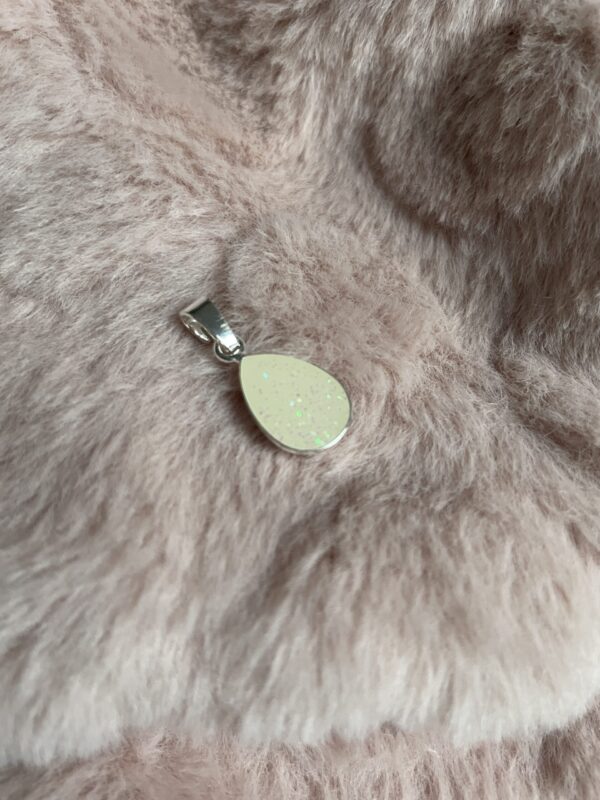 In dzeedruppelvormige hanger zit moedermelk en een beetje parelmoerachtige glitters