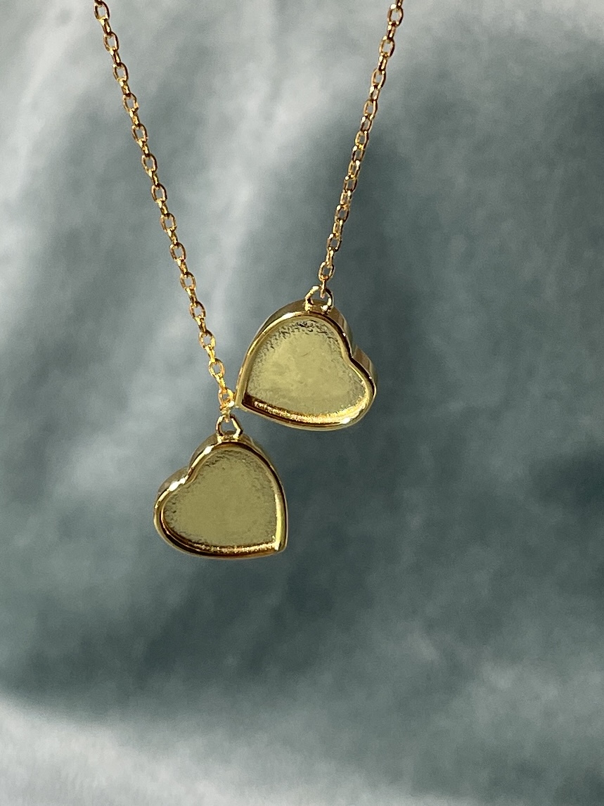 Deze love hanger heeft twee bedels waarin je moedermelk komt