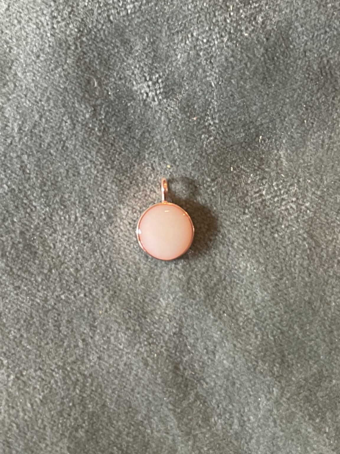 Deze Rossie is een hanger van rosé verguld en heeft een steentje van moedemelk