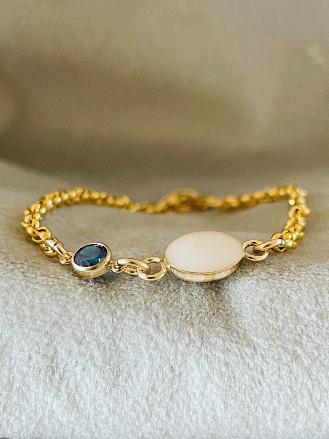 Deze armband heeft een borstmelk steentje en een geboortesteen